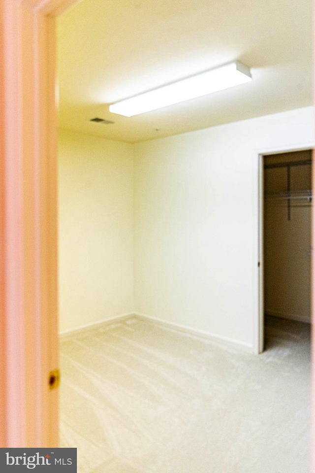 unfurnished bedroom with baseboards, visible vents, and carpet