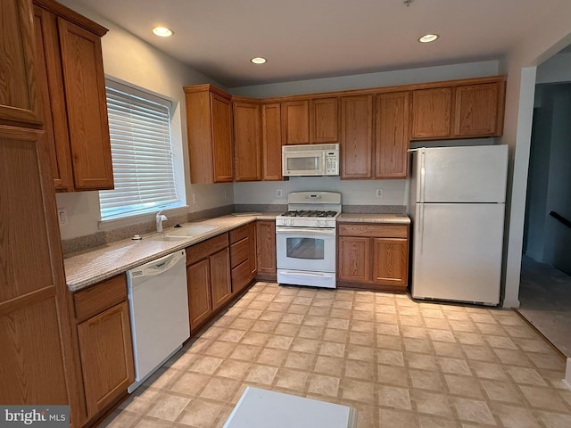 kitchen featuring recessed lighting, a sink, white appliances, brown cabinetry, and light countertops