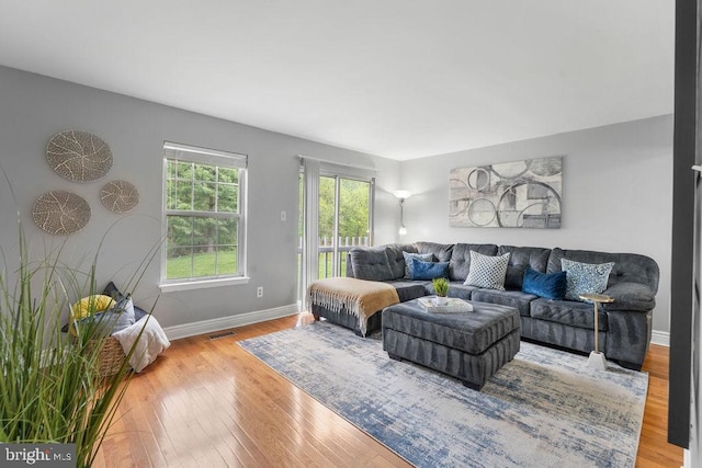 living area featuring baseboards, visible vents, and wood-type flooring