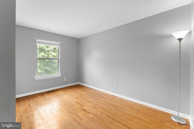 spare room featuring baseboards, visible vents, and light wood-style flooring