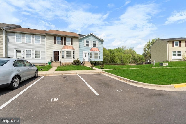multi unit property featuring uncovered parking and a front lawn