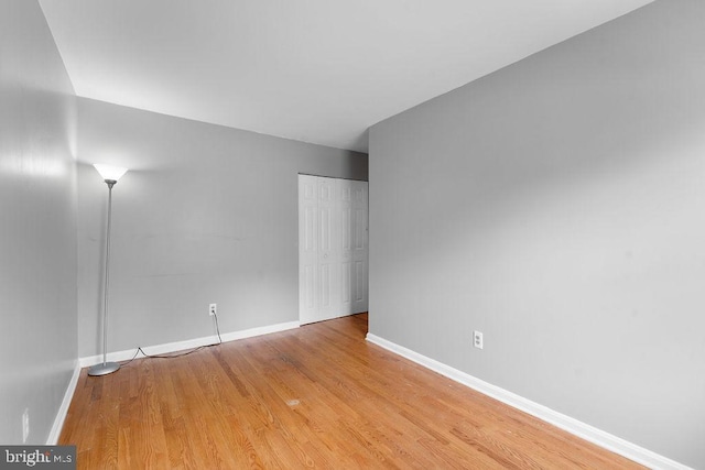 empty room featuring baseboards and light wood finished floors
