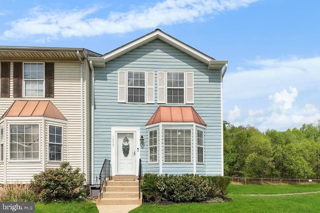 view of front of house featuring metal roof, a standing seam roof, and a front yard