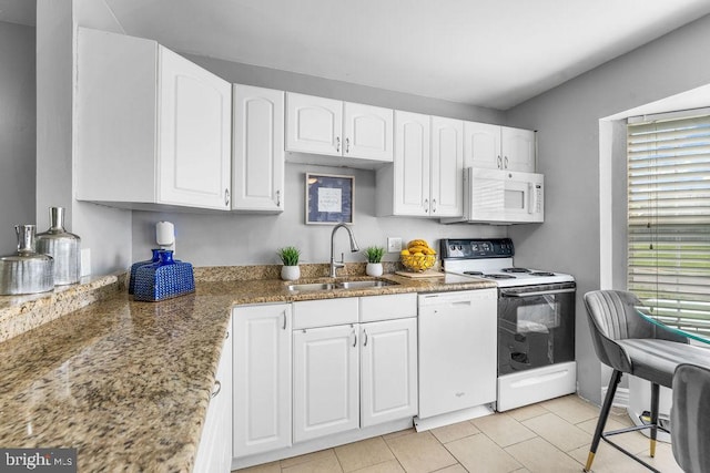 kitchen featuring stone counters, white appliances, white cabinets, and a sink