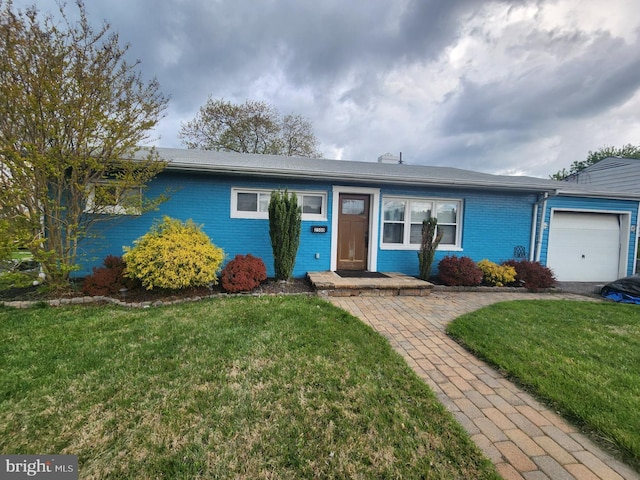 single story home featuring a front lawn, brick siding, and a garage