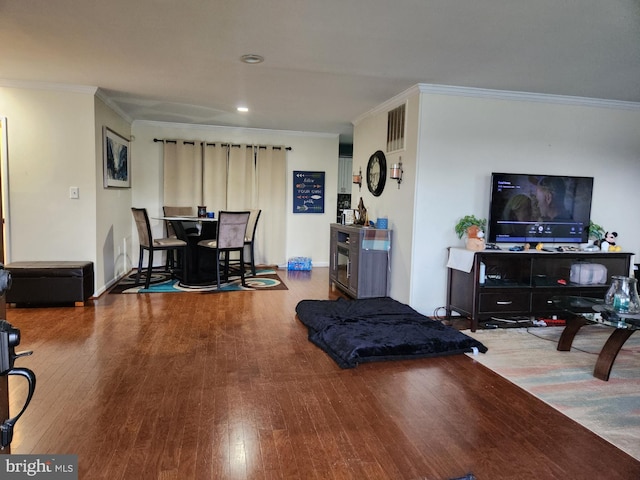 living room featuring crown molding, recessed lighting, visible vents, and wood finished floors