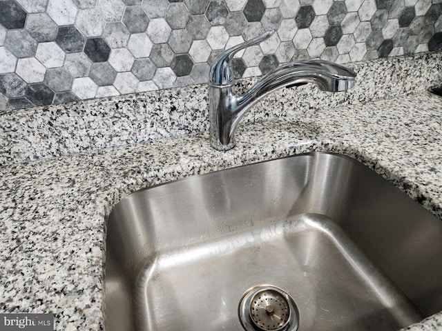room details with light stone counters and a sink