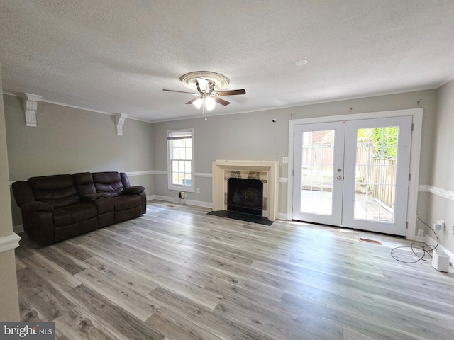 living room with french doors, ornamental molding, and light wood finished floors