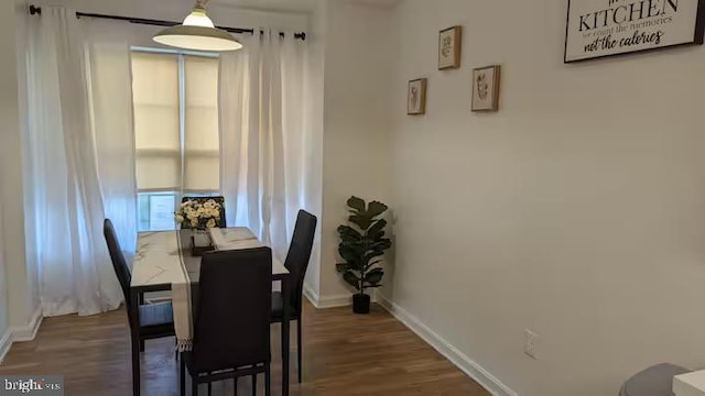 dining room with baseboards and wood finished floors