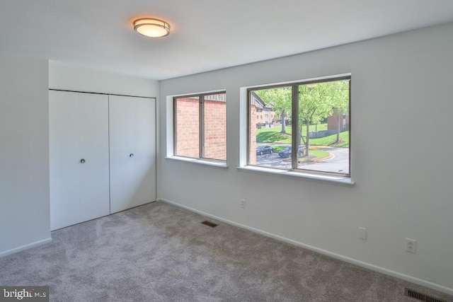 unfurnished bedroom featuring a closet, baseboards, carpet flooring, and visible vents
