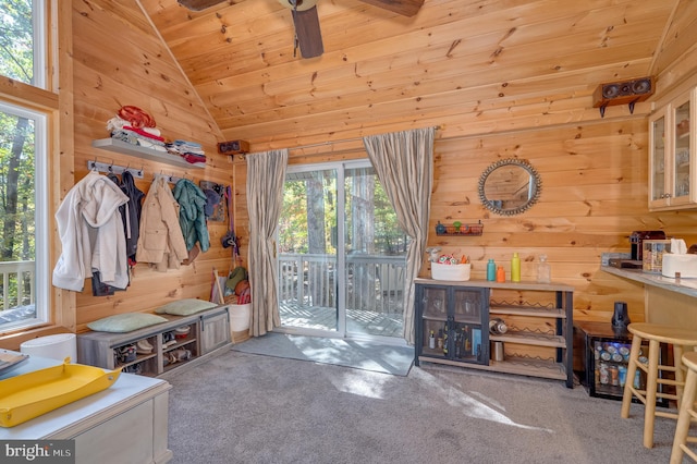 mudroom with wooden walls, carpet floors, a ceiling fan, wooden ceiling, and vaulted ceiling