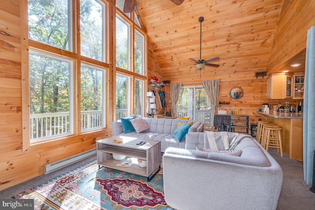 carpeted living area with high vaulted ceiling, wood walls, a ceiling fan, a baseboard radiator, and wood ceiling