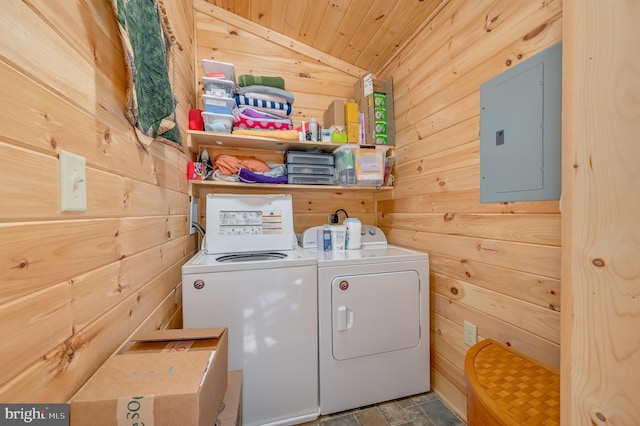 laundry room with wood ceiling, electric panel, laundry area, washing machine and clothes dryer, and wooden walls