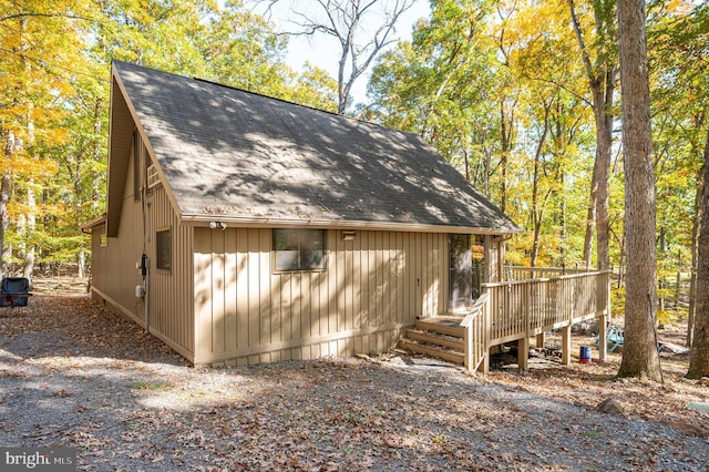 exterior space with a deck and a shingled roof