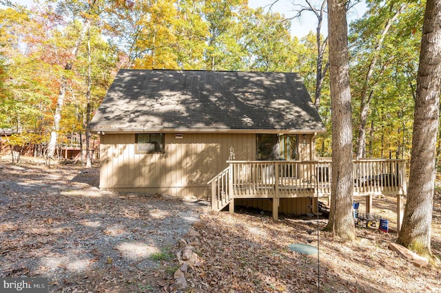 back of property featuring a wooden deck and roof with shingles