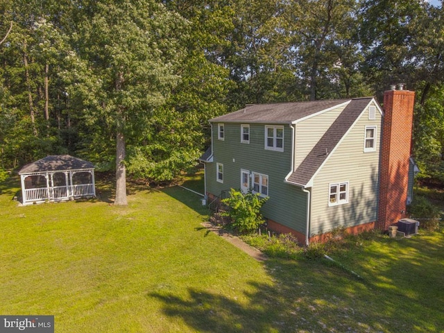 4564 Mountain Rd, Pasadena, MD 21122 - rear view of house with a lawn, a gazebo, central air condition unit, and a chimney