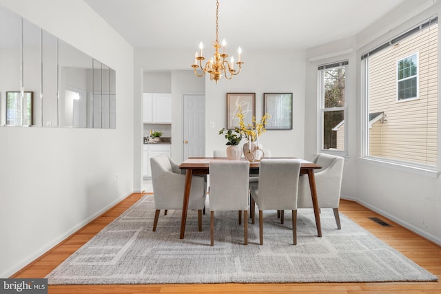 206 Cherrywood Ter, Gaithersburg, MD 20878 - dining space featuring a chandelier, light wood-style flooring, and baseboards