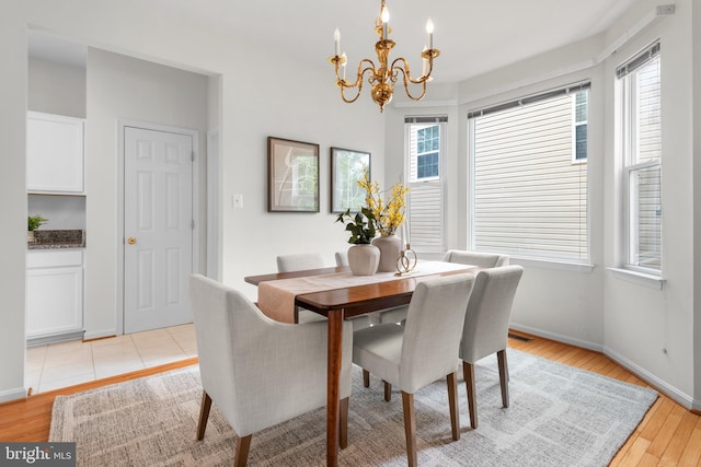 206 Cherrywood Ter, Gaithersburg, MD 20878 - dining room with a chandelier, light wood-type flooring, and baseboards