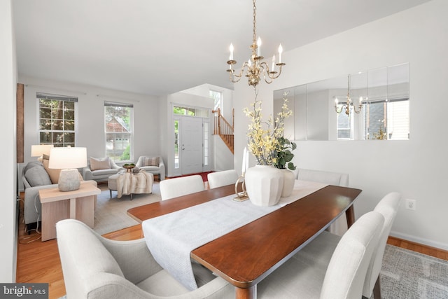 206 Cherrywood Ter, Gaithersburg, MD 20878 - dining area with a chandelier, wood finished floors, stairway, vaulted ceiling, and baseboards