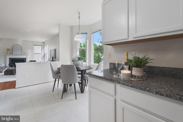 206 Cherrywood Ter, Gaithersburg, MD 20878 - kitchen featuring open floor plan, plenty of natural light, a fireplace, and dark stone countertops