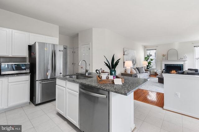 206 Cherrywood Ter, Gaithersburg, MD 20878 - kitchen with stainless steel appliances, a sink, white cabinetry, light tile patterned floors, and dark stone counters