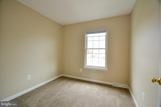 carpeted empty room featuring visible vents and baseboards
