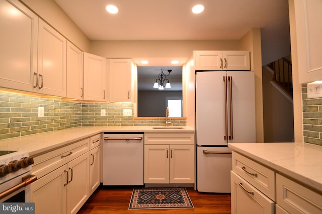 kitchen featuring white cabinetry, a sink, dark wood-style floors, recessed lighting, and white appliances