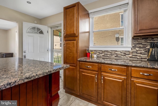 326 Glasgow St, Pottstown, PA 19464 - kitchen with light tile patterned floors, dark stone counters, brown cabinetry, and backsplash