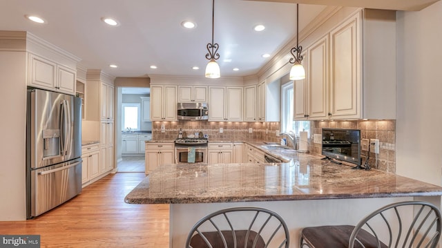 107 S Dover Ave, Atlantic City, NJ 08401 - kitchen with light stone counters, a peninsula, appliances with stainless steel finishes, and a healthy amount of sunlight