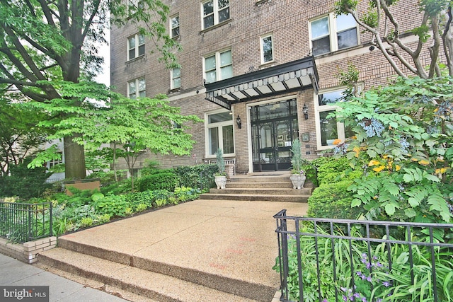 view of exterior entry featuring brick siding