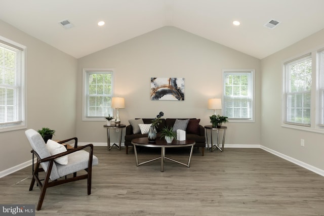 sitting room featuring baseboards, visible vents, wood finished floors, and vaulted ceiling
