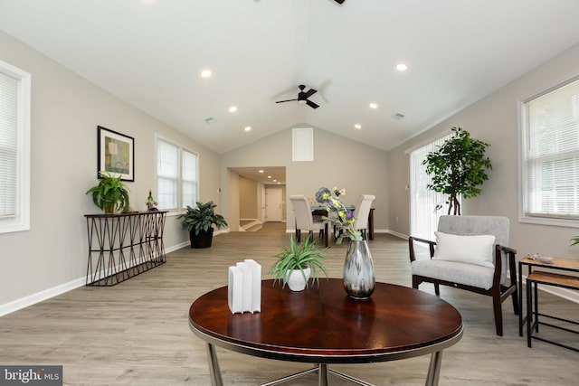 sitting room with ceiling fan, a healthy amount of sunlight, lofted ceiling, and light wood-type flooring