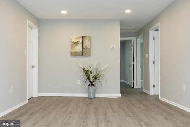 spare room with baseboards, recessed lighting, and wood finished floors