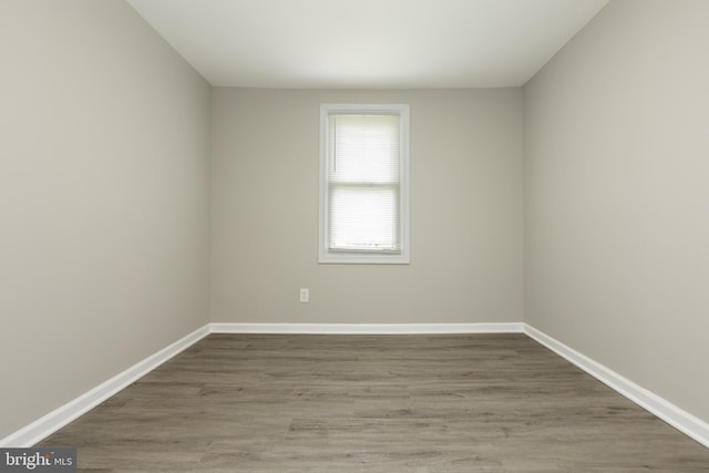 empty room with baseboards and wood finished floors
