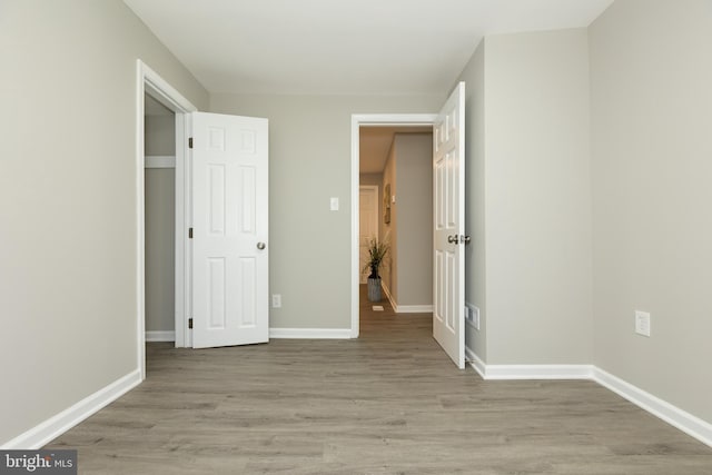 unfurnished bedroom featuring baseboards and light wood finished floors