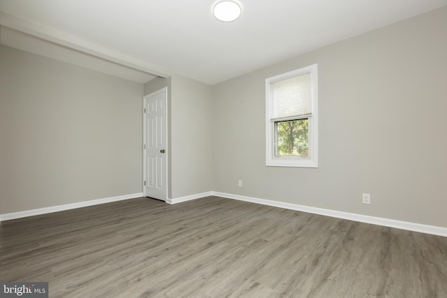 unfurnished room featuring baseboards and wood finished floors
