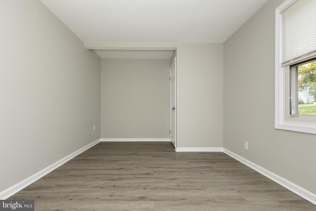 unfurnished room featuring baseboards and wood finished floors