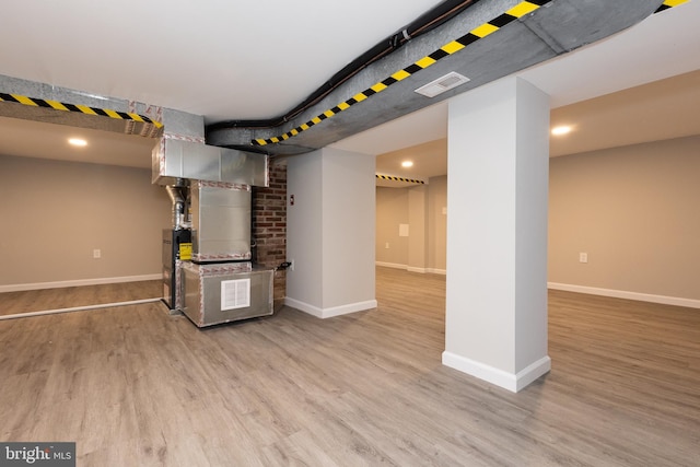 finished basement with baseboards and light wood-style flooring