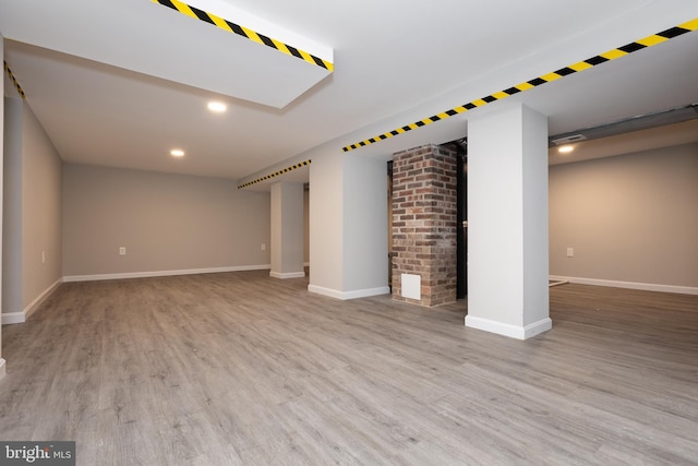 finished below grade area featuring recessed lighting, baseboards, and wood finished floors