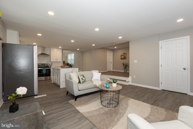 living area with visible vents, recessed lighting, baseboards, and wood finished floors