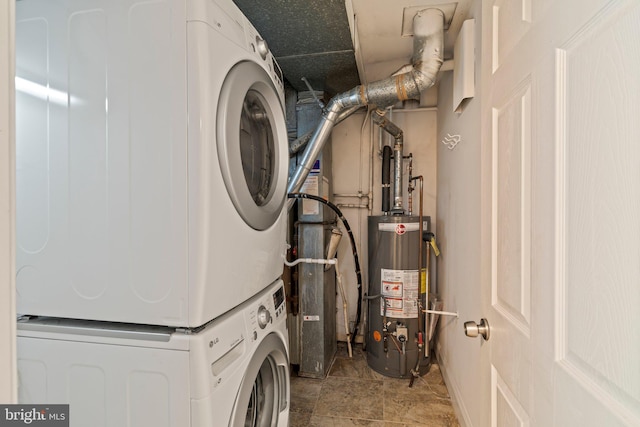 clothes washing area featuring estacked washer and dryer and water heater
