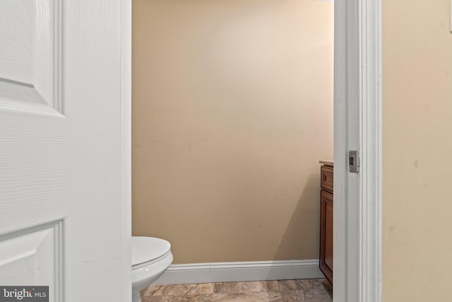 bathroom featuring toilet and baseboards