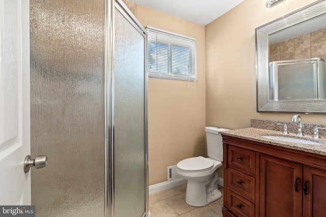 full bath featuring a stall shower, vanity, toilet, tile patterned flooring, and baseboards