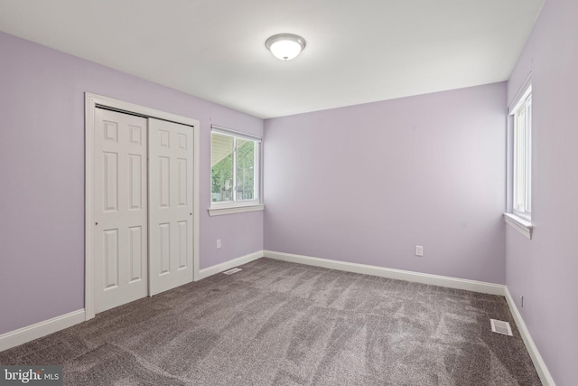 unfurnished bedroom with carpet flooring, a closet, and baseboards