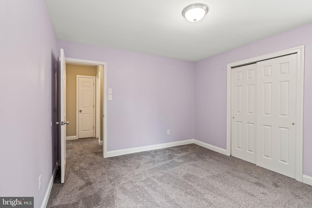 unfurnished bedroom featuring carpet, baseboards, and a closet