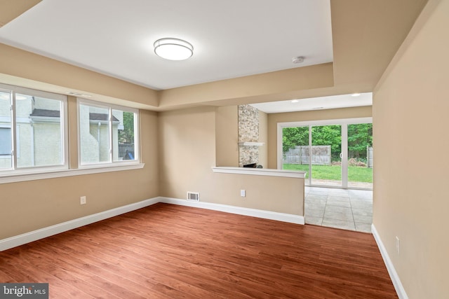 empty room with wood finished floors, baseboards, and a smoke detector