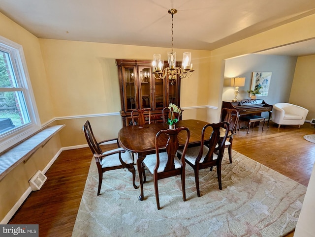 dining room with an inviting chandelier, wood finished floors, visible vents, and baseboards