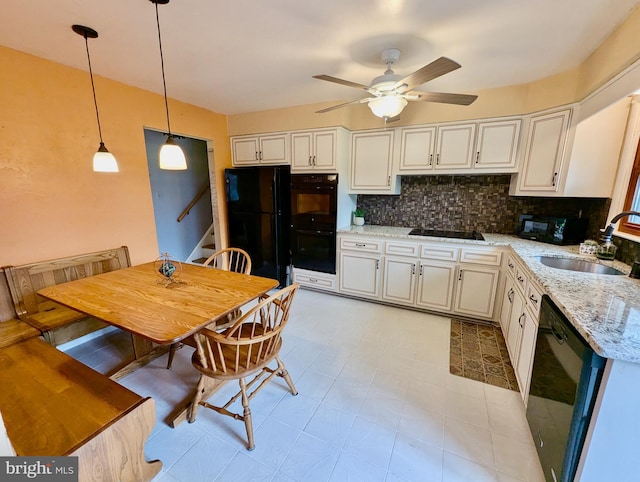 kitchen with decorative backsplash, a sink, ceiling fan, black appliances, and hanging light fixtures