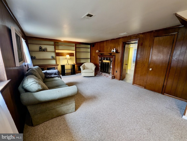 living area featuring visible vents, wood walls, carpet, and a fireplace