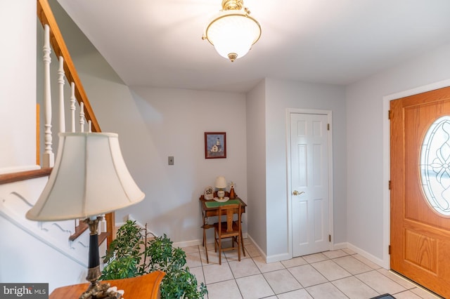 entrance foyer with stairs, baseboards, and light tile patterned floors